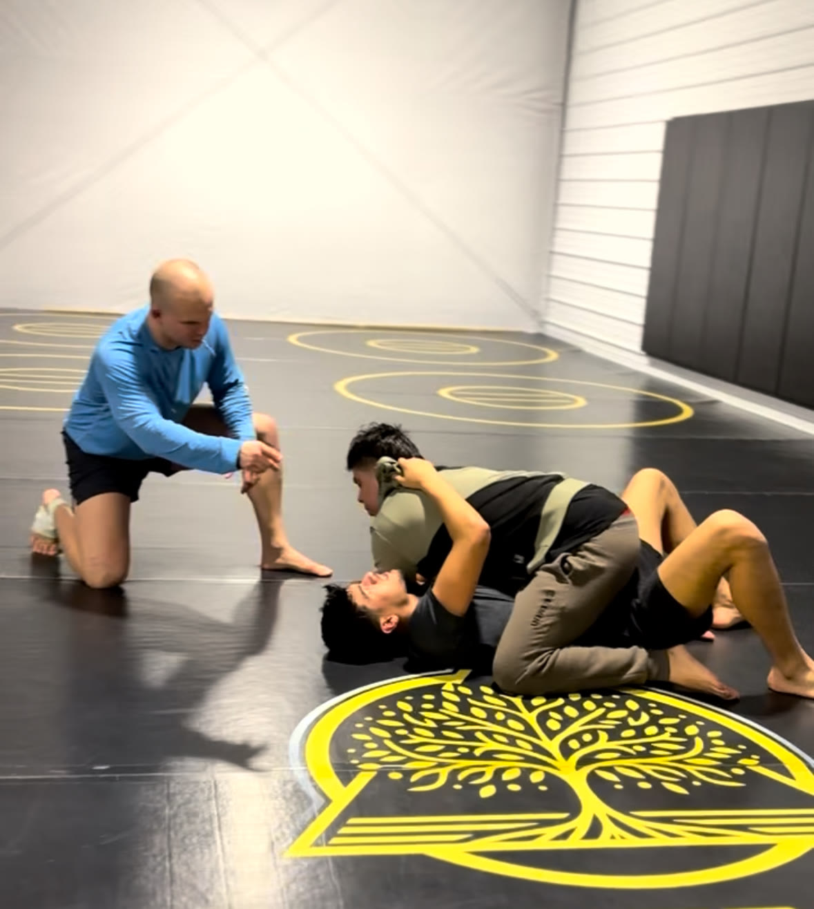A coach pausing class to walk students through a technique step by step