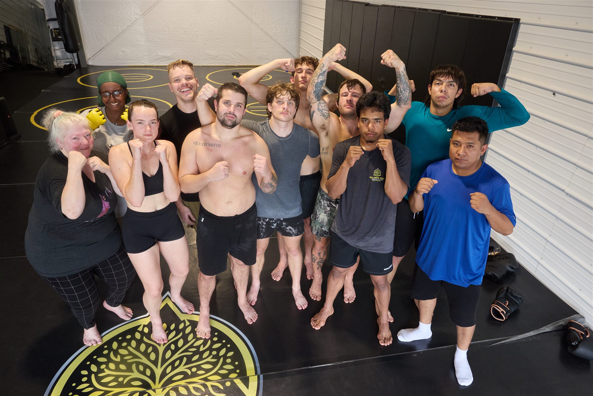 The whole Golden Oak crew flexing together over the logo mat after training