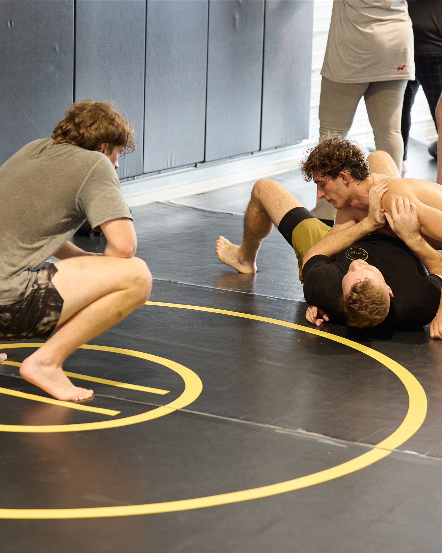 Live jiu-jitsu rounds on the mats with the coach watching over the room