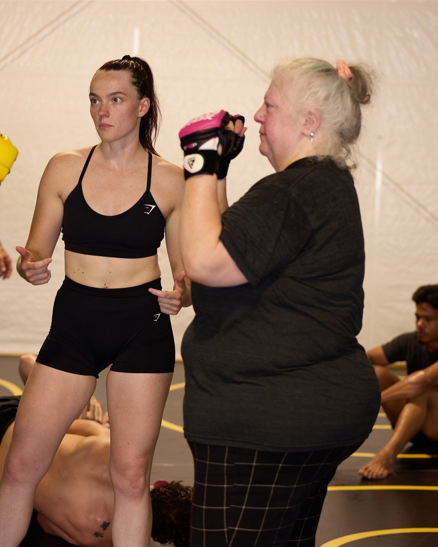 Three generations of women drilling strikes together in women's self-defense class