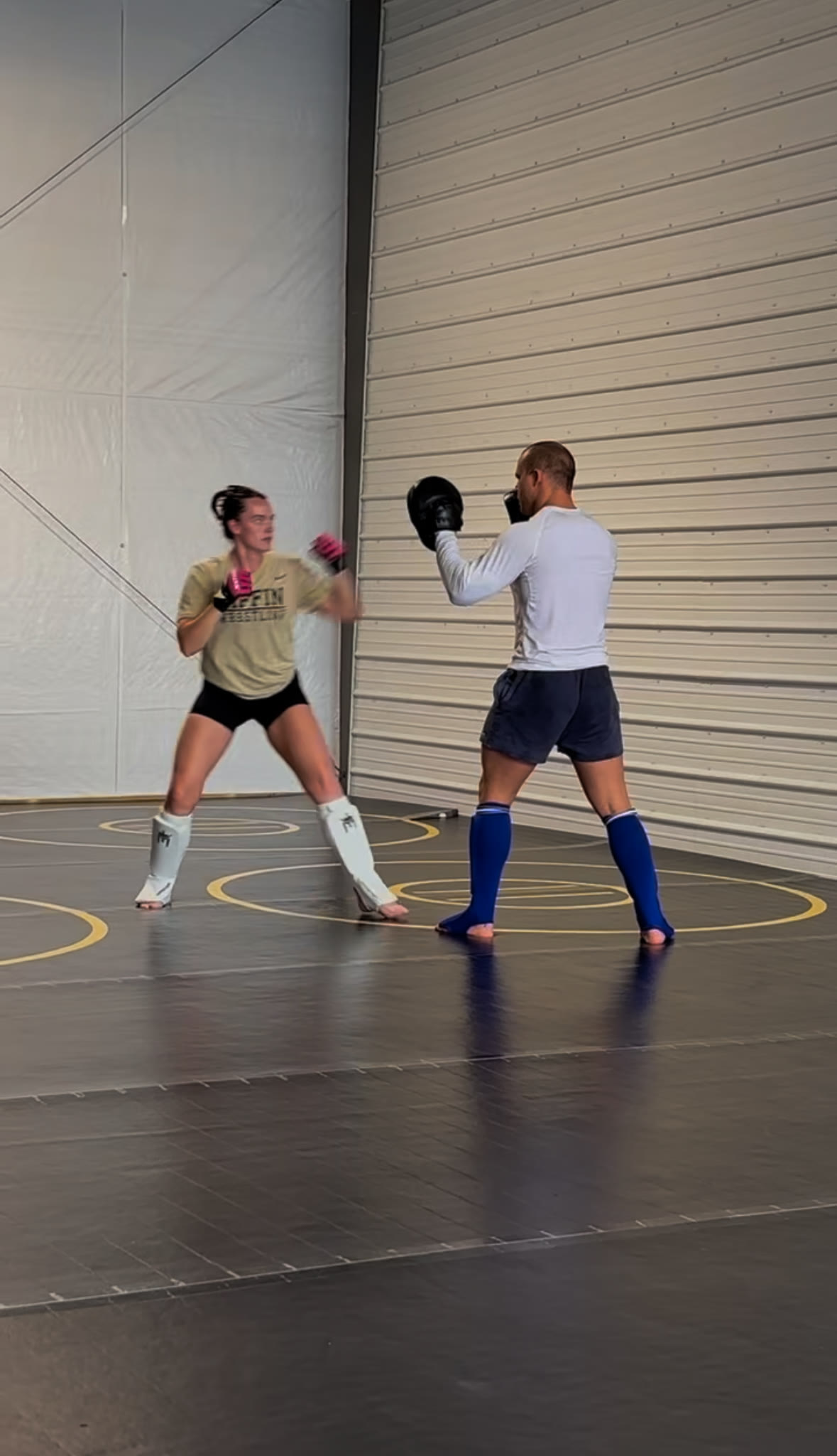 A member throwing punches into a coach's mitts during women's self-defense class