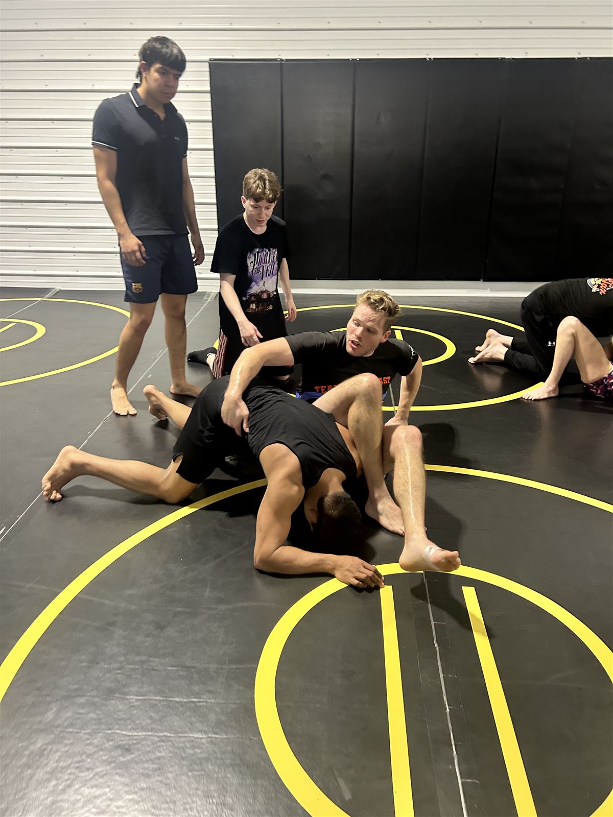 Coach finishing an omoplata during a no-gi jiu-jitsu roll